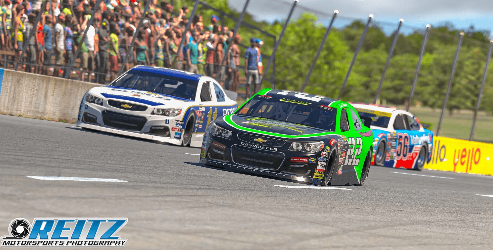 Three stock cars battling through a short-track corner